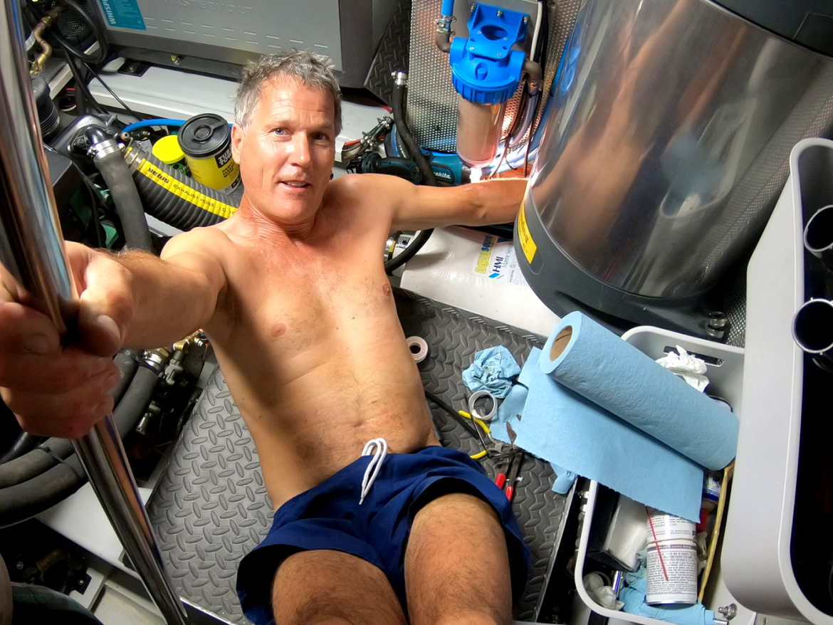 Glen works his abs while tightening the fitting under the waterheater