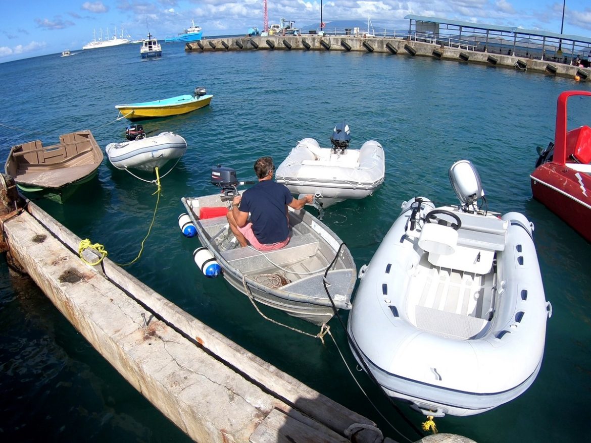 Bailing out a dinghy on the town quay in Charlestown, Nevis Bailing out a dinghy on the town quay in Charlestown, Nevis